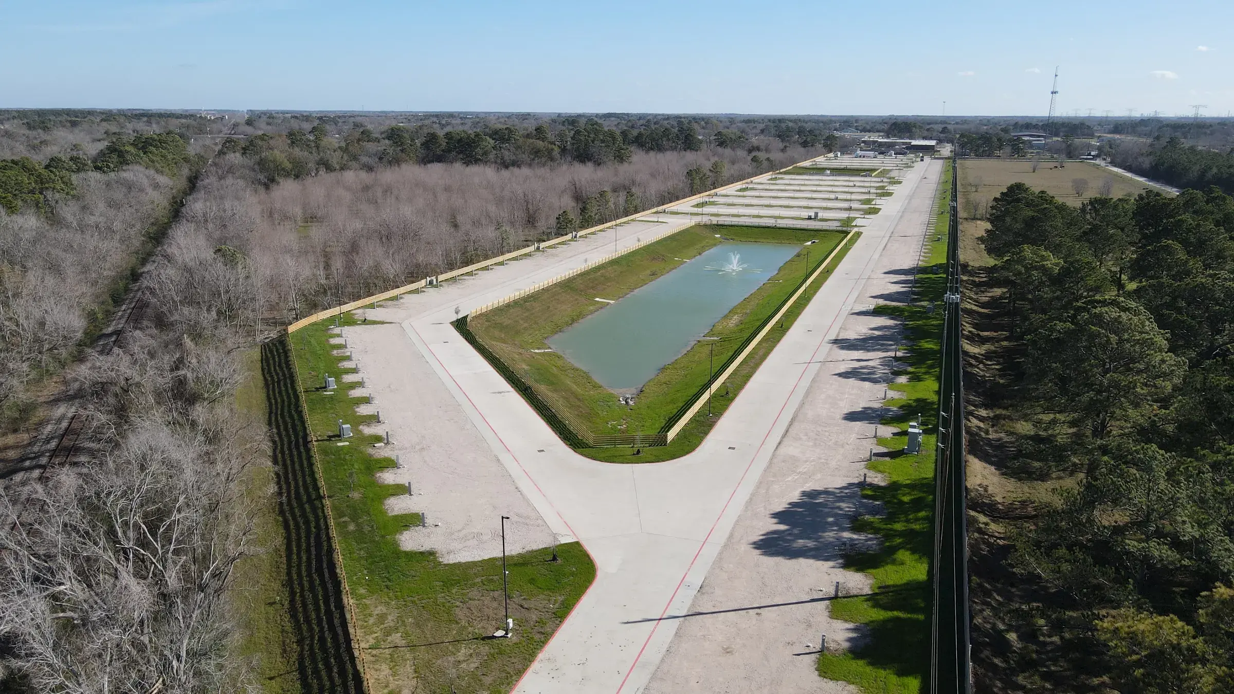 Aerial of the development with the detention pond in the foreground and finished pads running back behind it