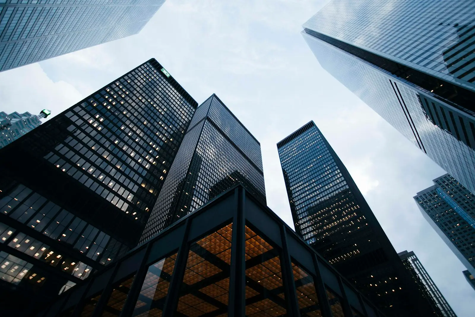 Commercial glass office towers seen looking upward against a pale sky