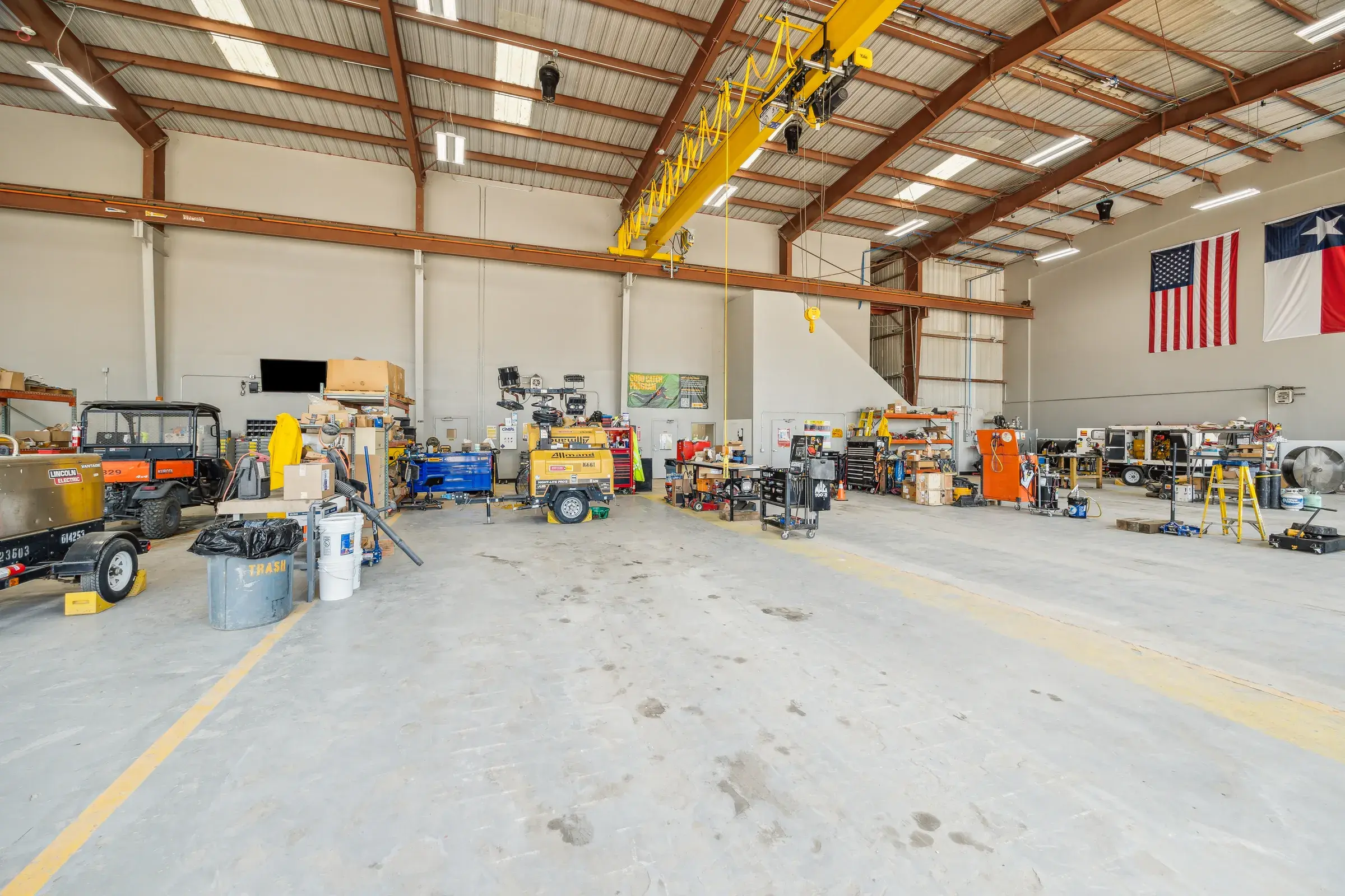 A service bay under the overhead crane with machines in for repair beneath the exposed steel frame
