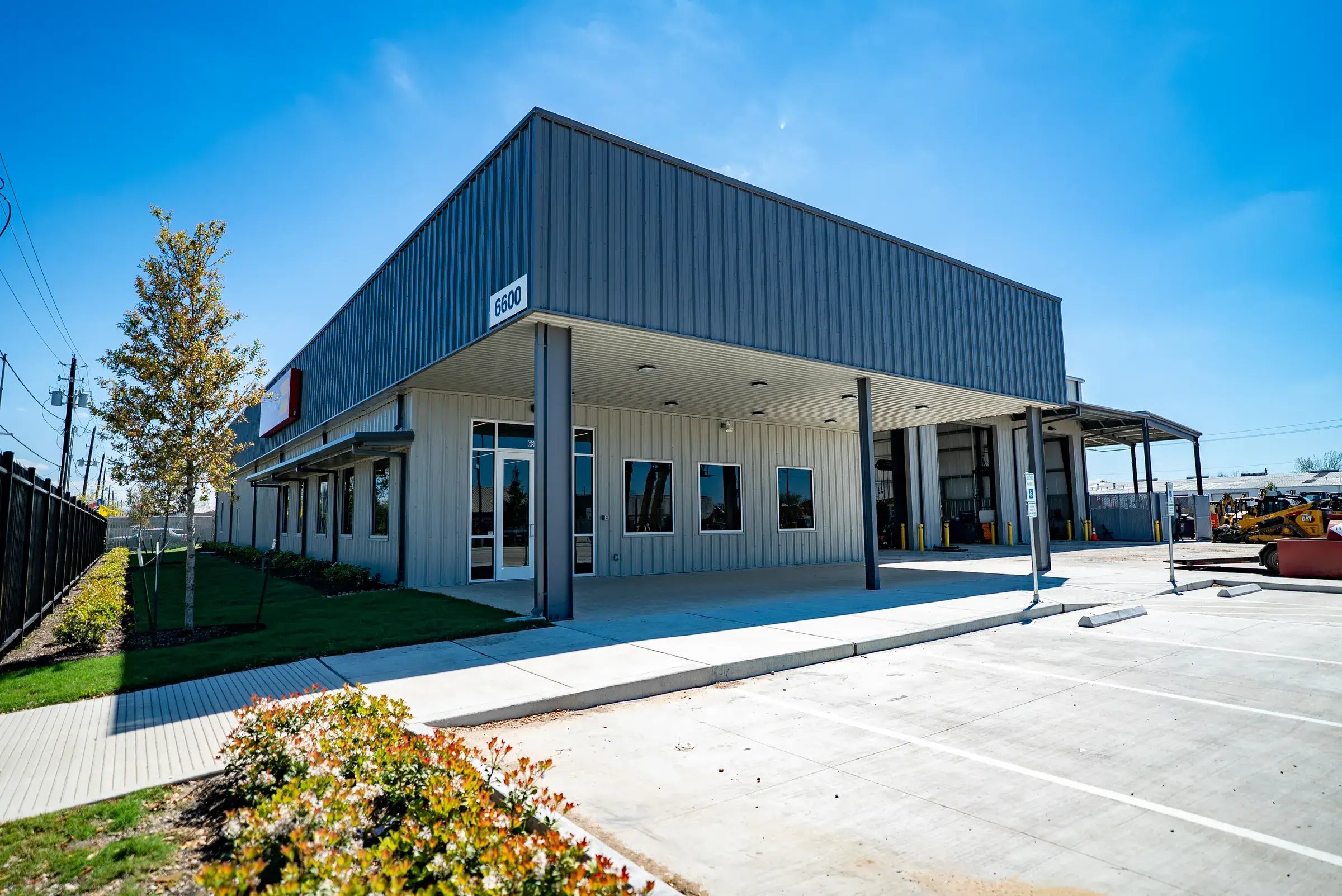 The completed Mustang CAT Long Drive facility, storefront entrance and service building under a clear sky