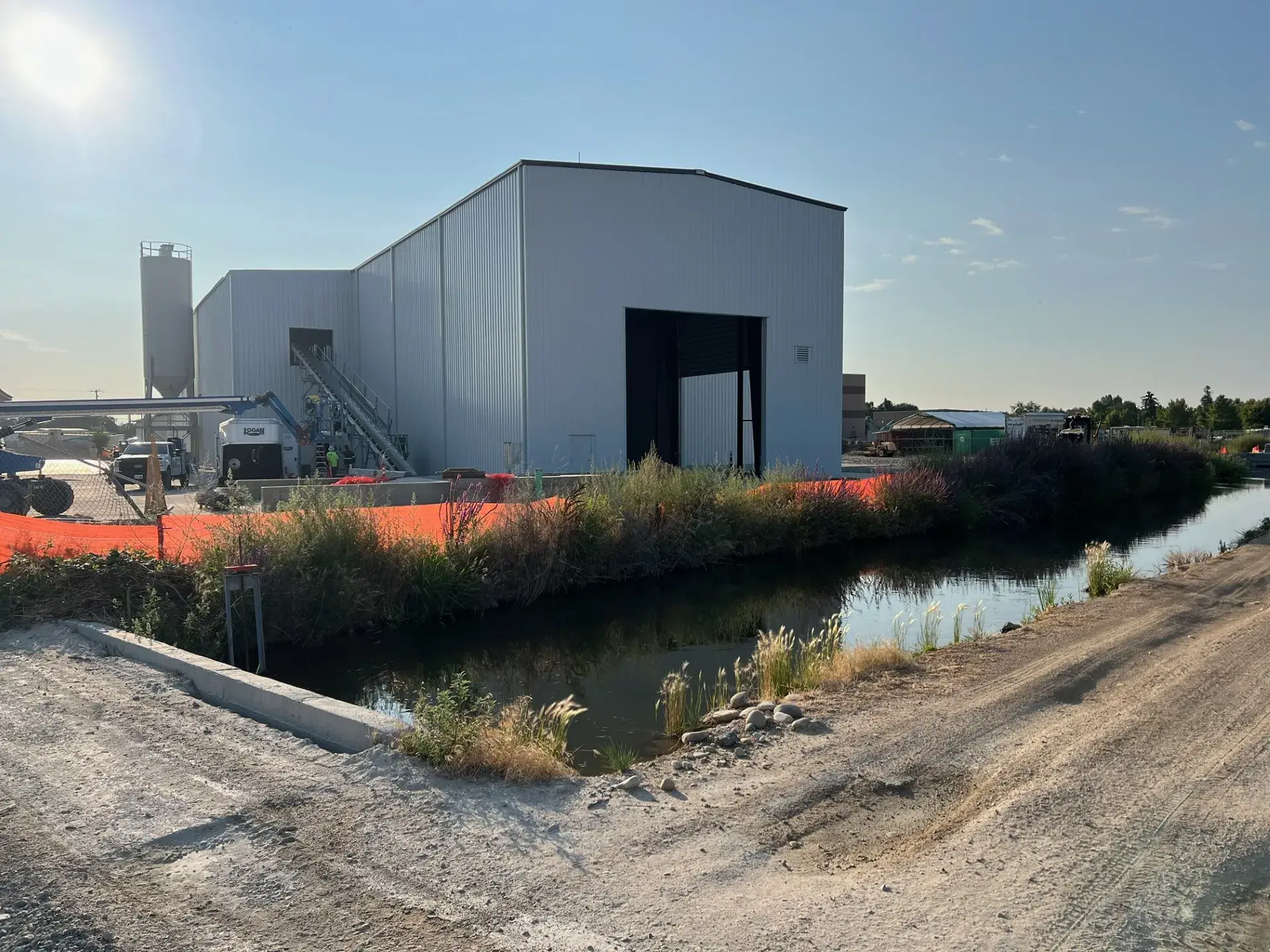 The finished plant seen across the irrigation canal that runs along the site, with the batch plant at the left end of the building