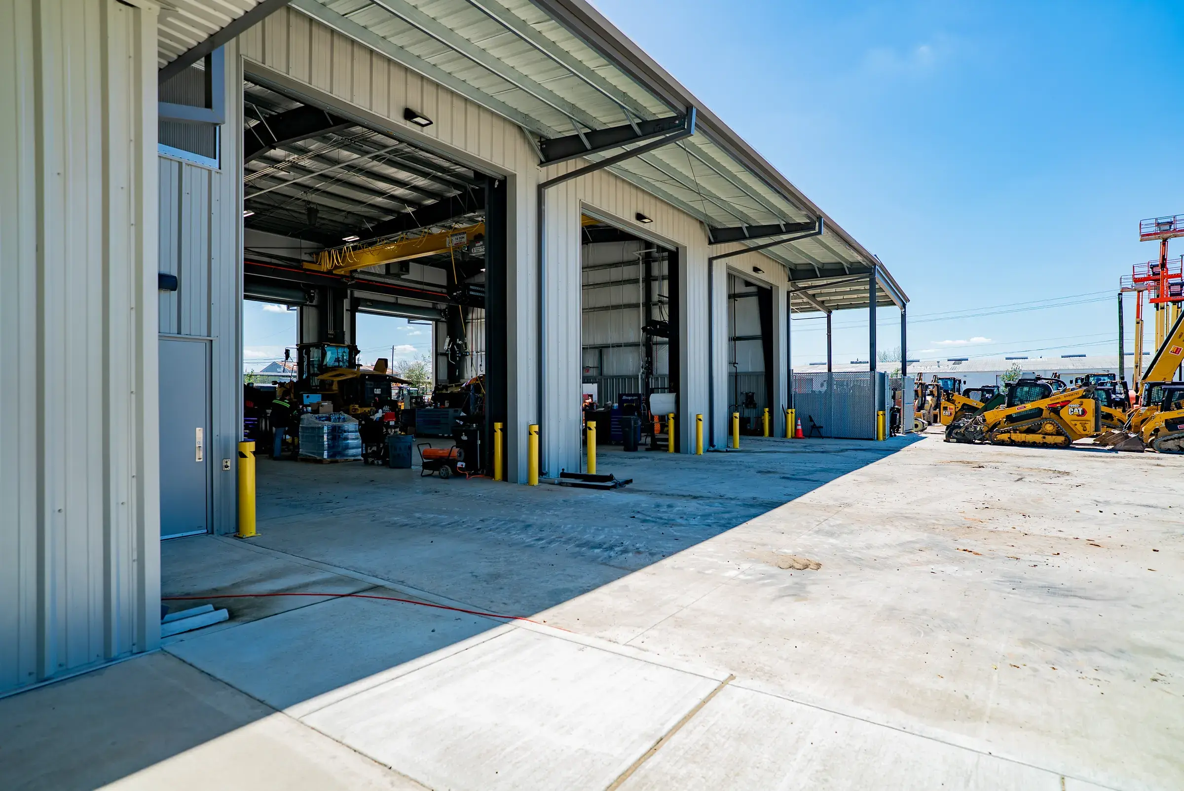 An open service bay with overhead crane rail and equipment staged inside